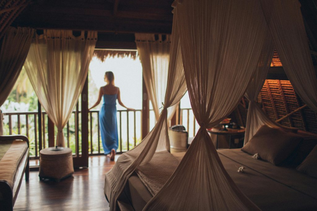 Peaceful bedroom in tropical villa with balcony view, perfect for relaxation.