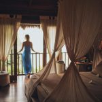 Peaceful bedroom in tropical villa with balcony view, perfect for relaxation.