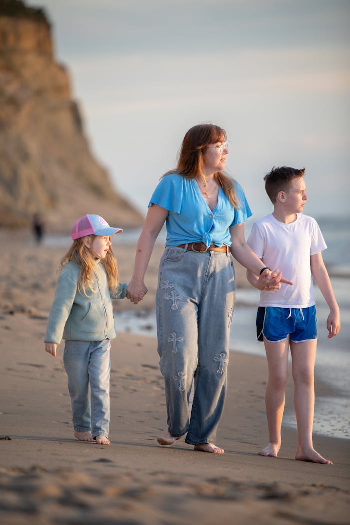 about-img Mother and children enjoying a peaceful walk along the beach during sunset.